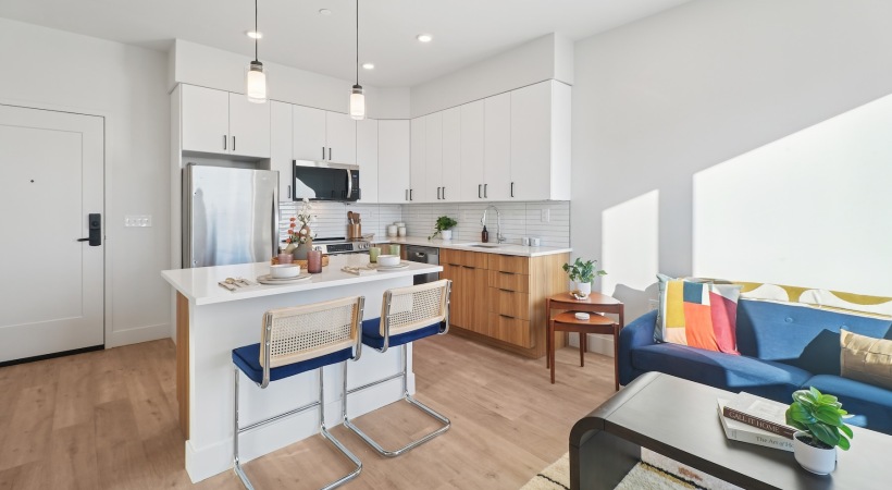 a kitchen and a living room with a couch and chairs
