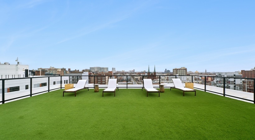 a lounge with grass and chairs
